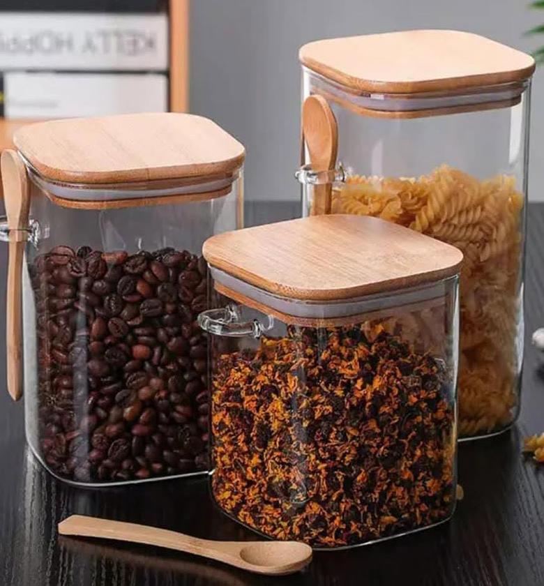 Glass storage jar with wooden lid and spoon. image
