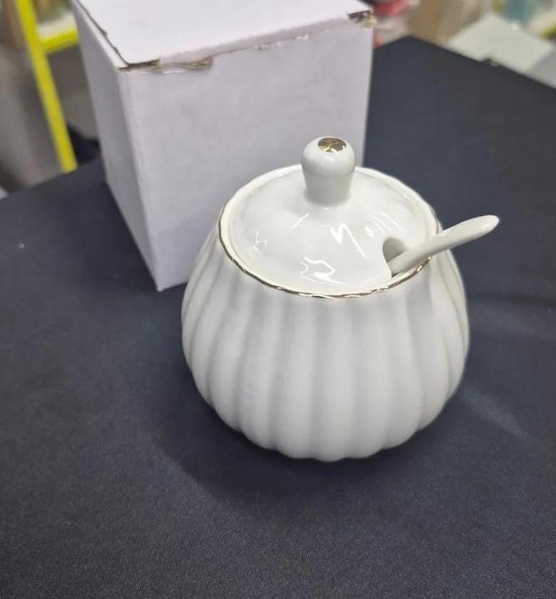 Gold rimmed ceramic sugar dish with spoon image