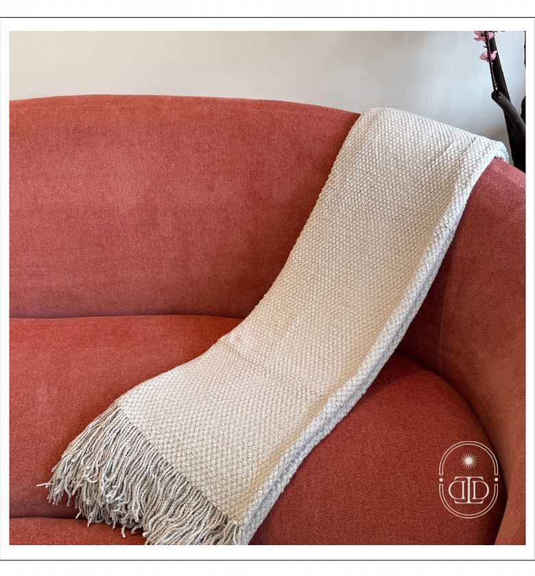 Light grey throw blanket with tassels. image
