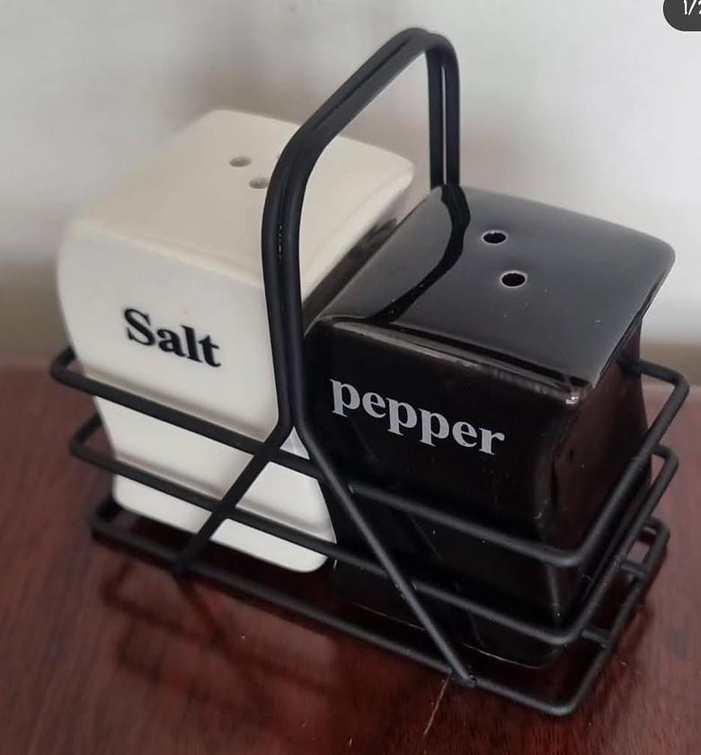 Salt and pepper shaker pot in black metal rack. image