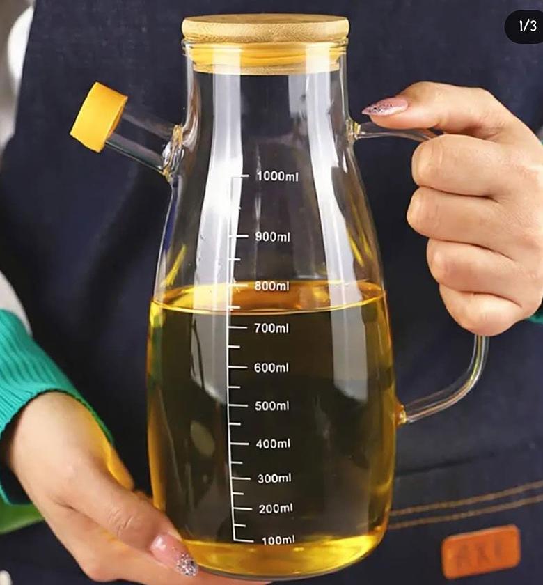 Glass oil dispenser with bamboo lid. image